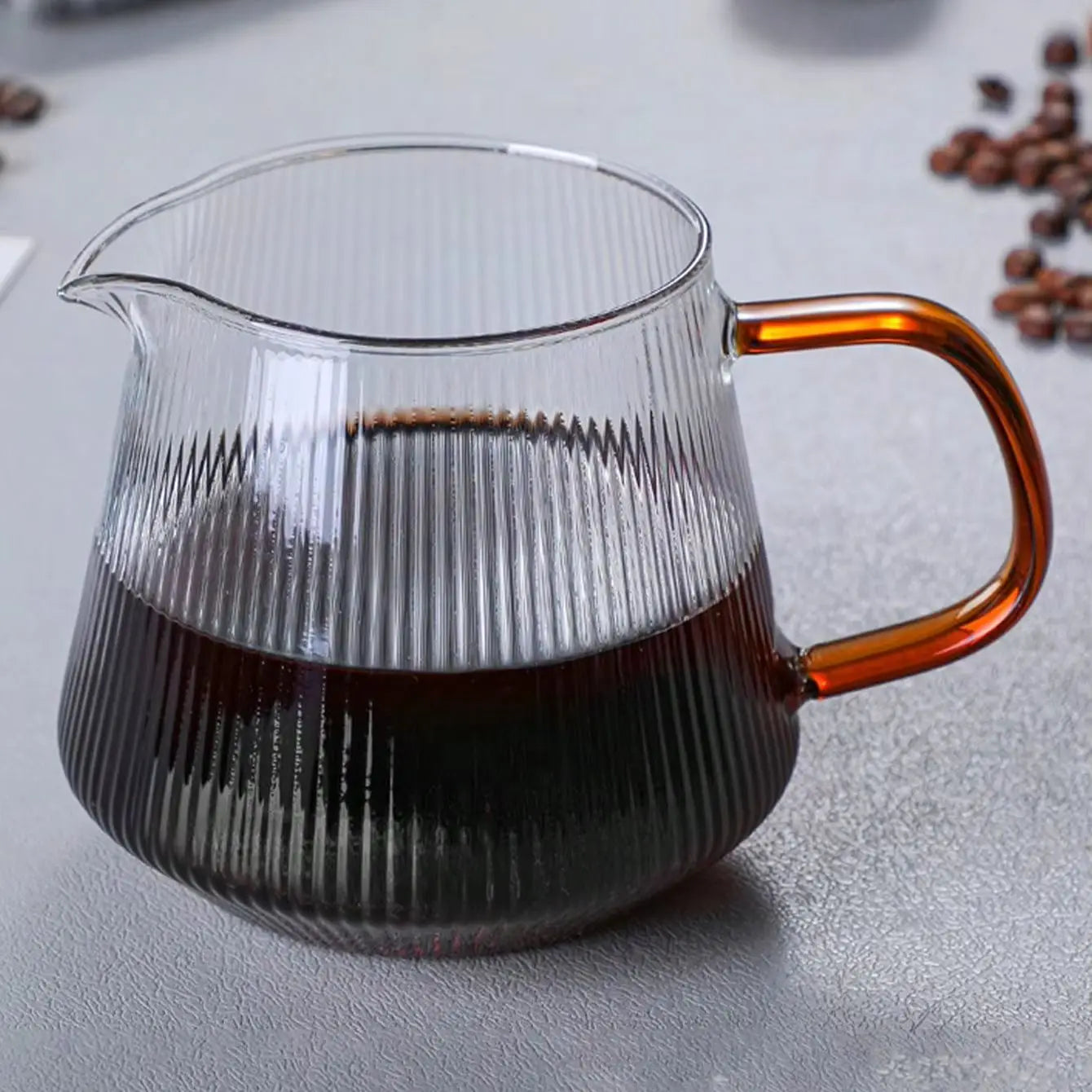 Verseuse en verre rayé remplie de café