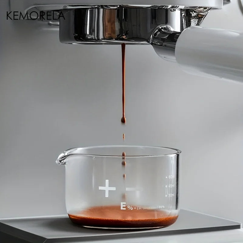 Verre gradué transparent sous une machine à espresso