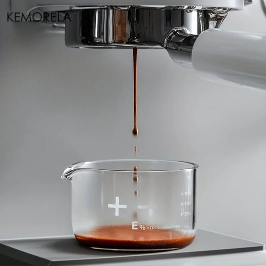 Verre gradué transparent sous une machine à espresso